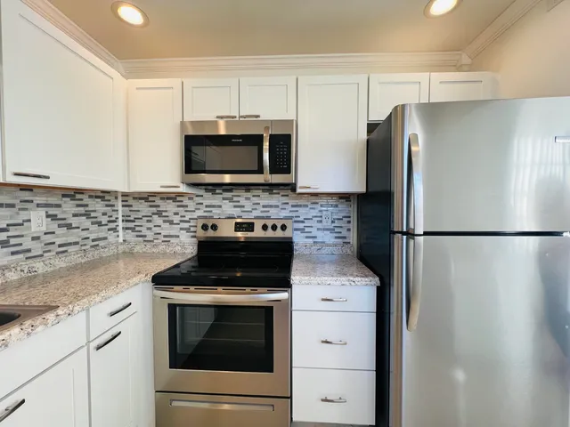 a kitchen with stainless steel appliances a refrigerator stove and microwave