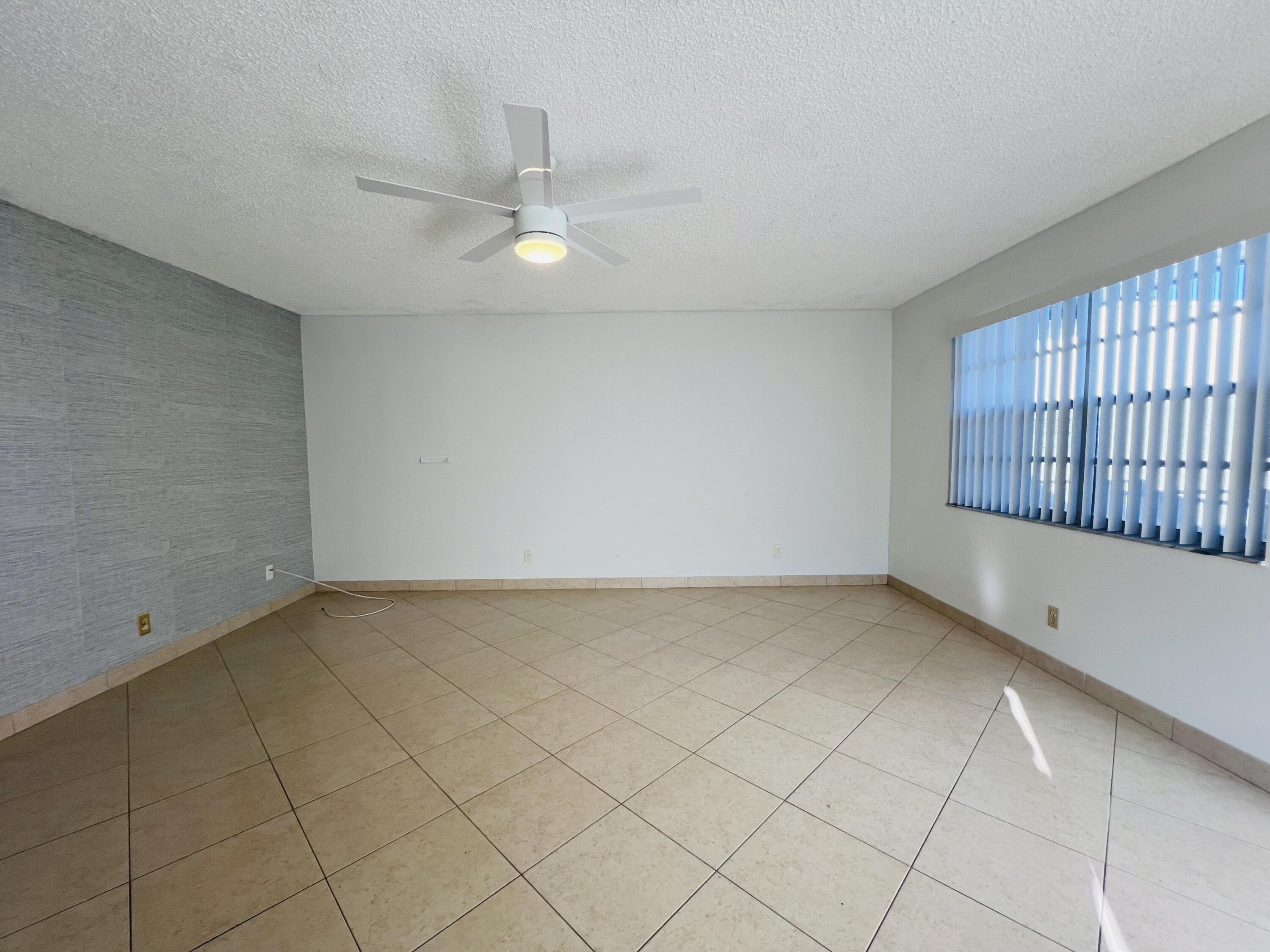 82 Normandy B Delray Beach, FL 33484 - Photo 6 of 31 an empty room with a ceiling fan and window