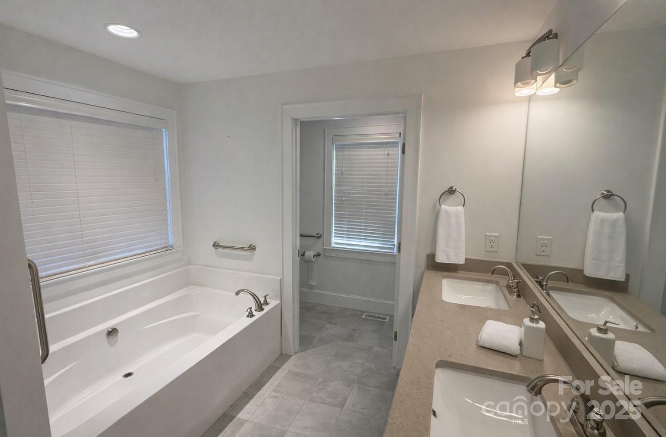 686 Elizabeth Street Southwest Concord, NC 28025 - Photo 12 of 44 a bathroom with a tub sink and mirror