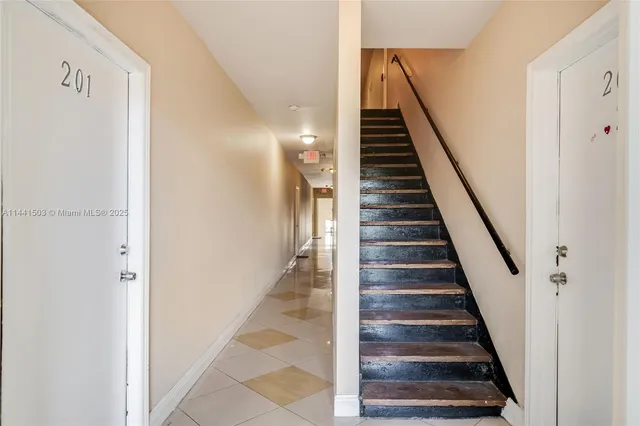 a view of staircase with wooden floor and white walls