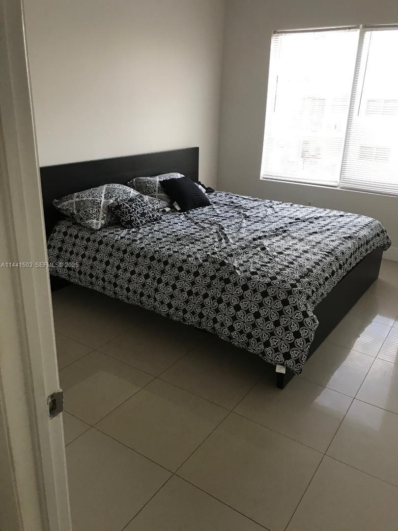 440 Southwest 5th Avenue Miami, FL 33130 - Photo 19 of 46 a bed sitting in a bedroom next to a window