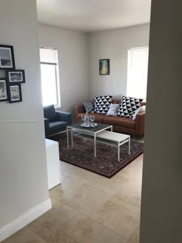a living room with a couch and a view of kitchen