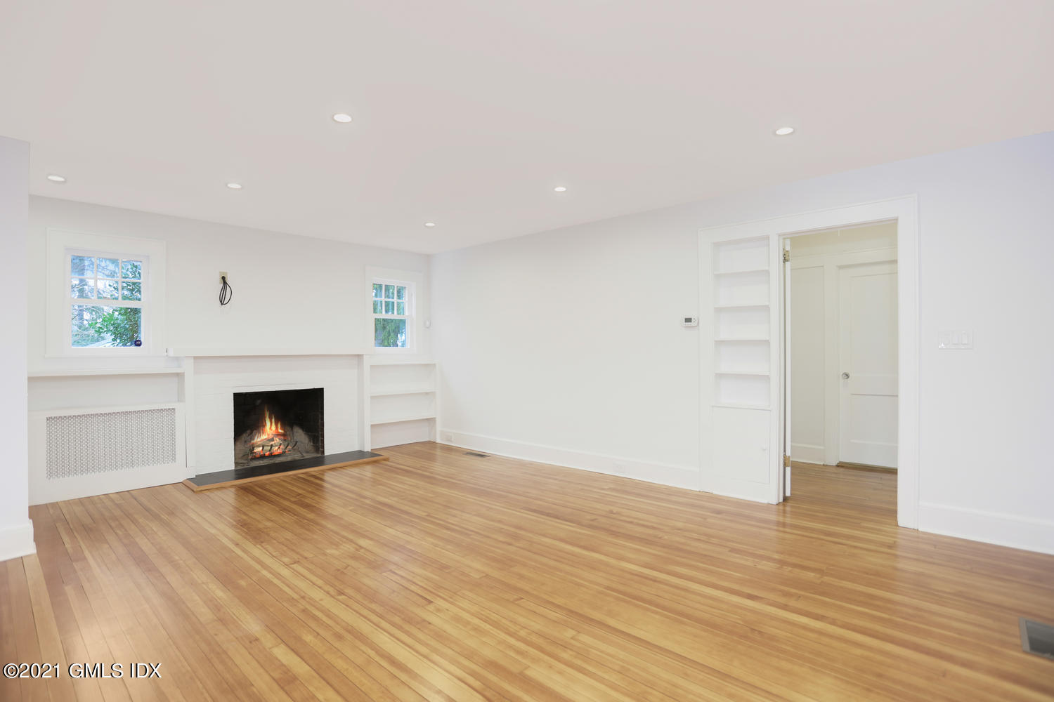 8 Potter Drive Old Greenwich, CT 06870 - Photo 3 of 11 an empty room with wooden floor and fireplace