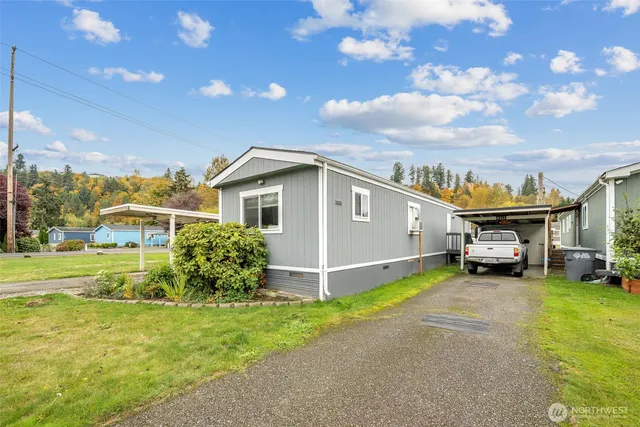 a view of a house with a big yard and large trees