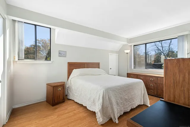 a bedroom with a bed and a large window