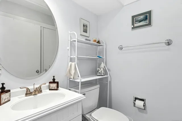 a bathroom with a sink mirror vanity and toilet