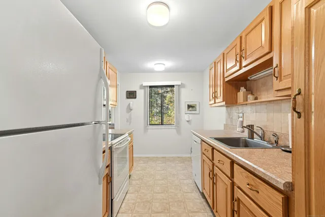 a kitchen with granite countertop a refrigerator and a sink