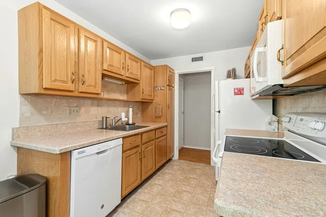 a kitchen with stainless steel appliances granite countertop a sink and a stove