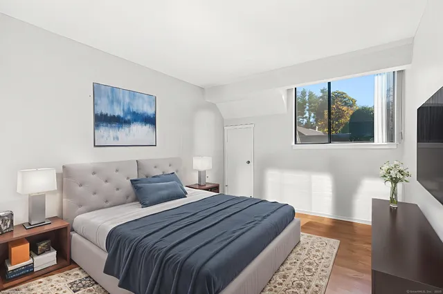 a bedroom with a bed and a painting on the wall