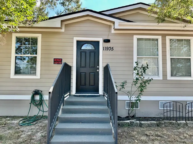 a front view of a house with plants