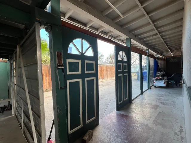 an empty room with floor to ceiling windows and fireplace