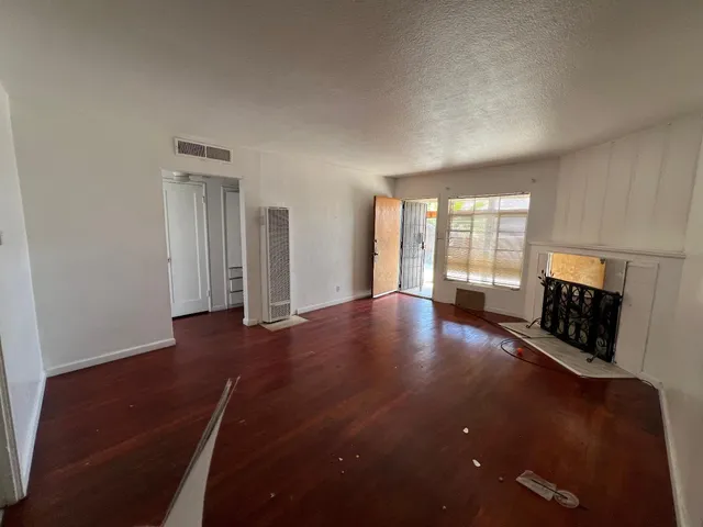 a view of an empty room with wooden floor
