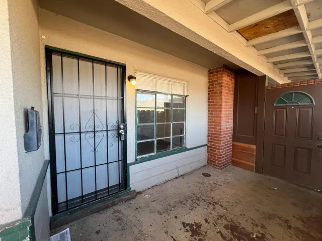a view of a house with a door and wooden walls