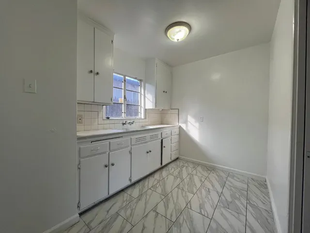 a room with a sink cabinets and wooden floor
