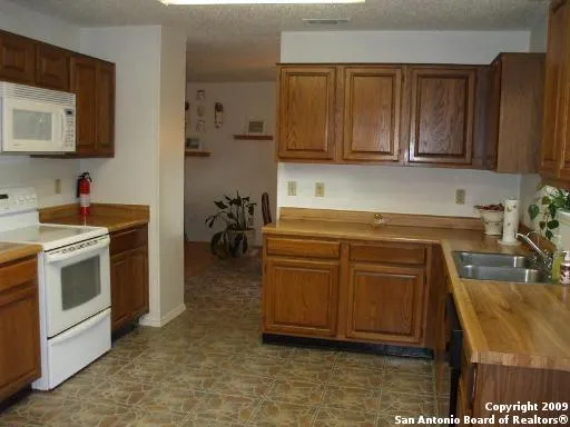 a kitchen with stainless steel appliances granite countertop a sink a stove and cabinets