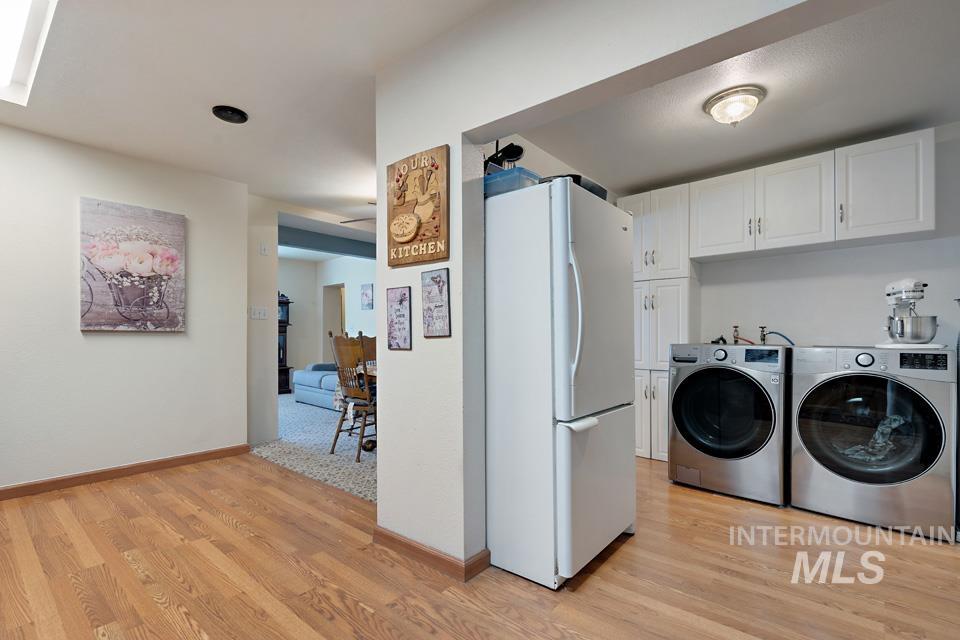 1015 East Park Street Weiser, ID 83672 - Photo 14 of 30 Laundry room featuring cabinet space, light wood finished floors, and washer and clothes dryer