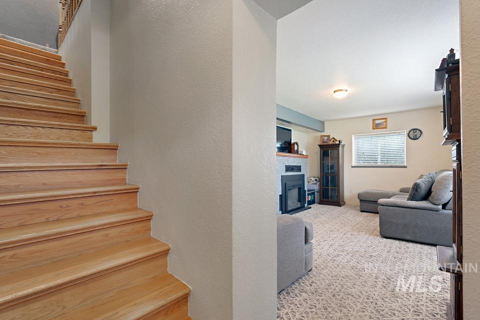 1015 East Park Street Weiser, ID 83672 - Photo 20 of 30 Stairway with a fireplace, a textured wall, and carpet