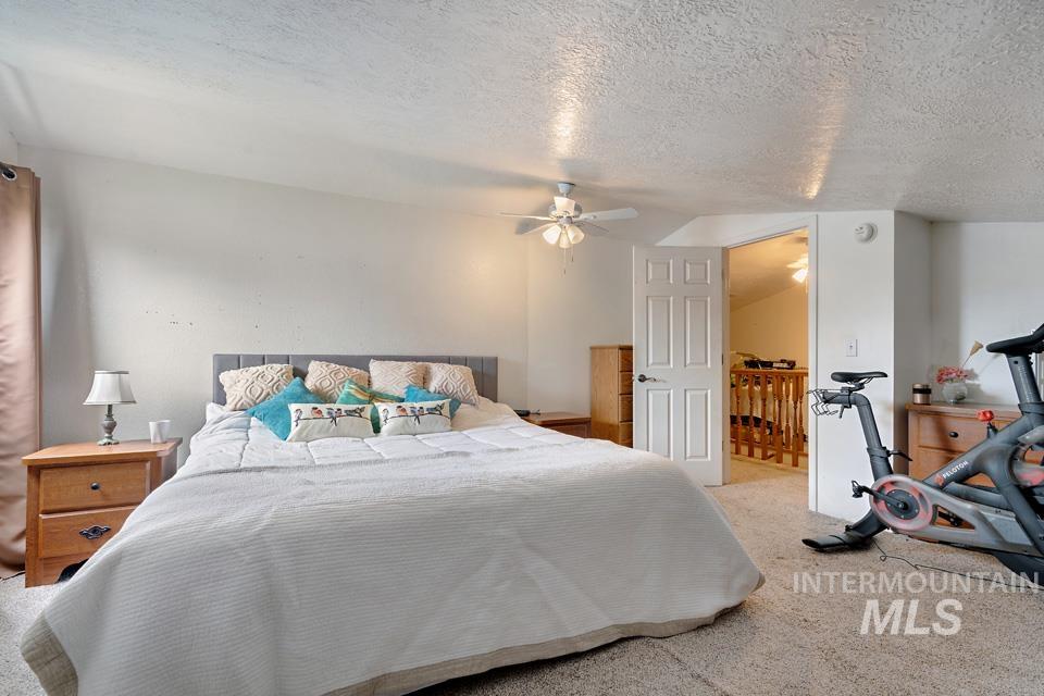 1015 East Park Street Weiser, ID 83672 - Photo 22 of 30 Bedroom with carpet flooring, a textured ceiling, ceiling fan, and vaulted ceiling