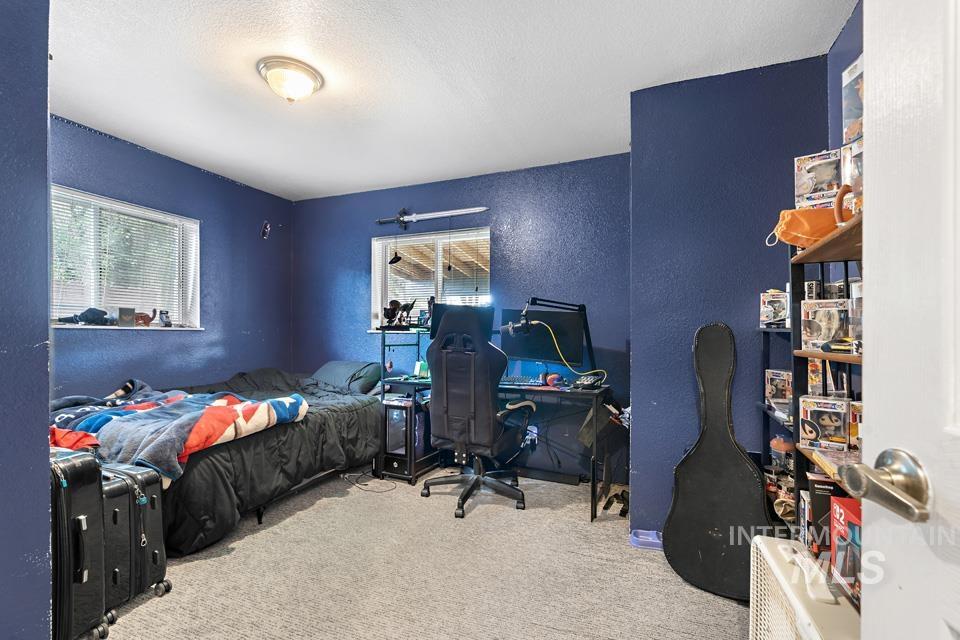1015 East Park Street Weiser, ID 83672 - Photo 30 of 30 Bedroom with a textured wall, multiple windows, light colored carpet, a textured ceiling, and an office area