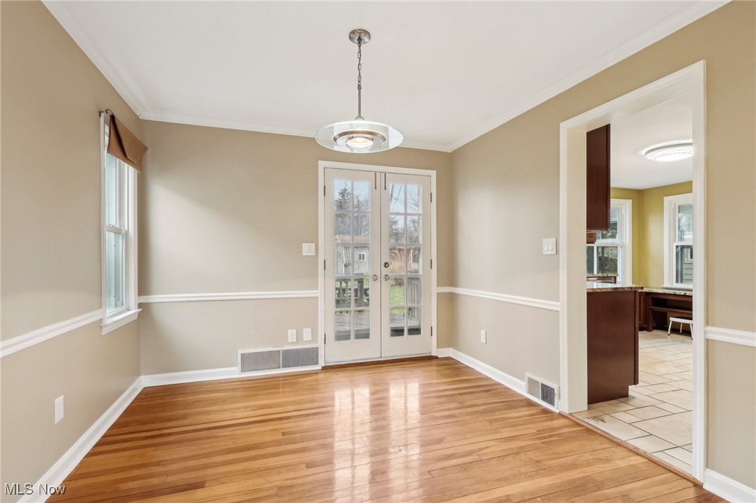 1311 Clearview Road Cleveland, OH 44124 - Photo 9 of 45 Unfurnished dining area featuring crown molding and light hardwood / wood-style flooring