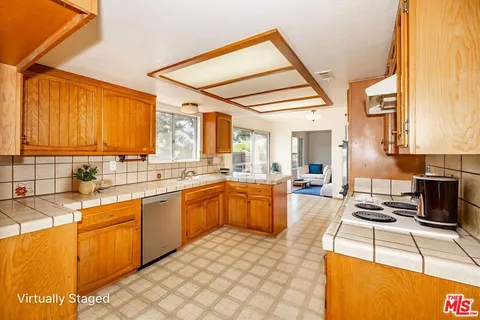 a large kitchen with stainless steel appliances kitchen island granite countertop a sink and cabinets