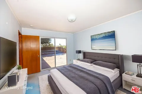 a bedroom with a large bed and a flat screen tv