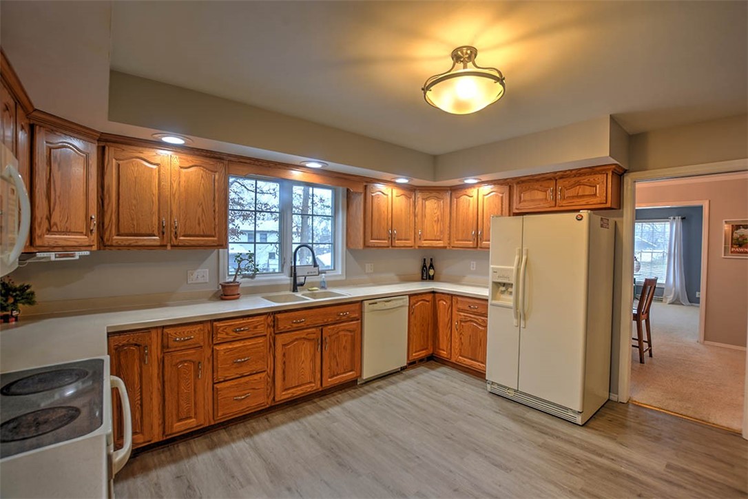 46 Woodhill Court Decatur, IL 62521 - Photo 10 of 32 a kitchen with stainless steel appliances granite countertop a refrigerator a sink dishwasher a stove and white countertops with wooden floor