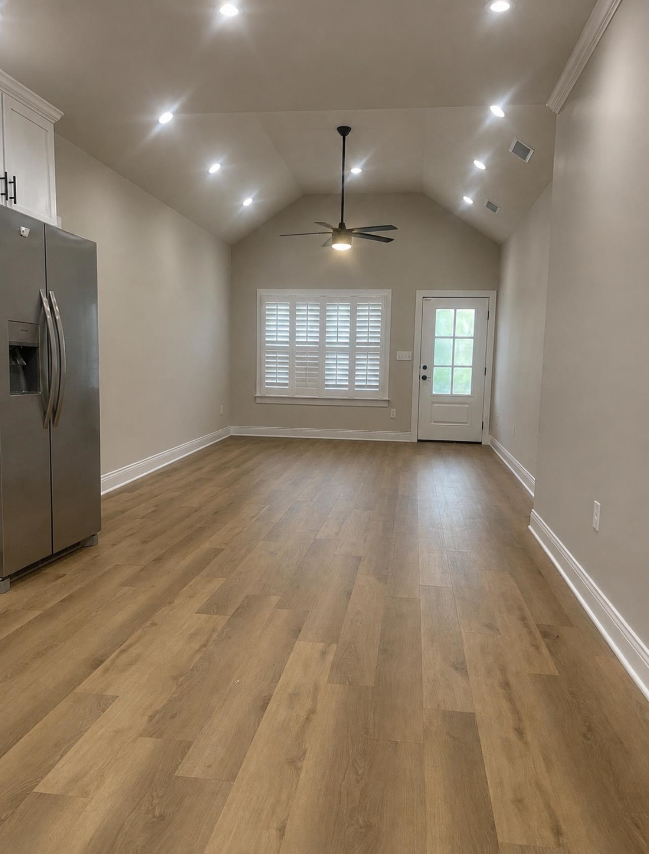 210 Church Street Ripley, TN 38063 - Photo 4 of 21 Open concept room featuring vaulted ceilings, recessed lighting, wood-finish flooring, and a stainless steel refrigerator