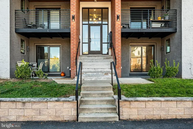 a front view of a house with potted plants