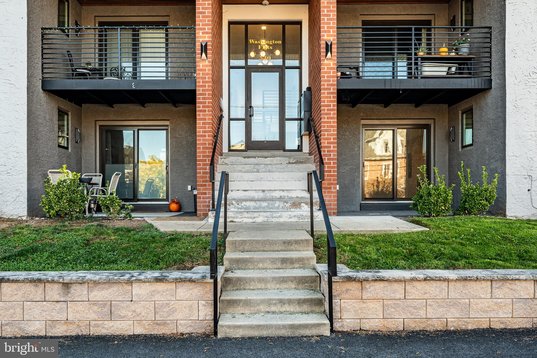 a front view of a house with potted plants