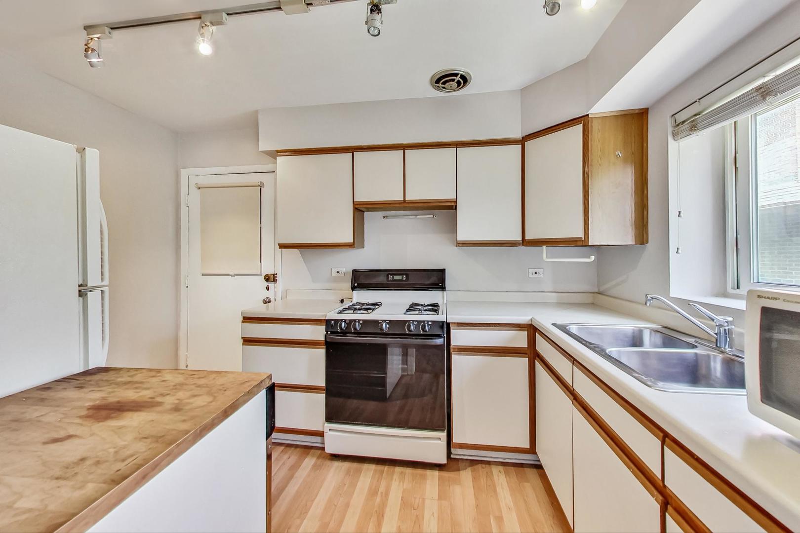 7400 North Sheridan Road, Unit 2 Chicago, IL 60626 - Photo 12 of 23 a kitchen with a stove sink and cabinets