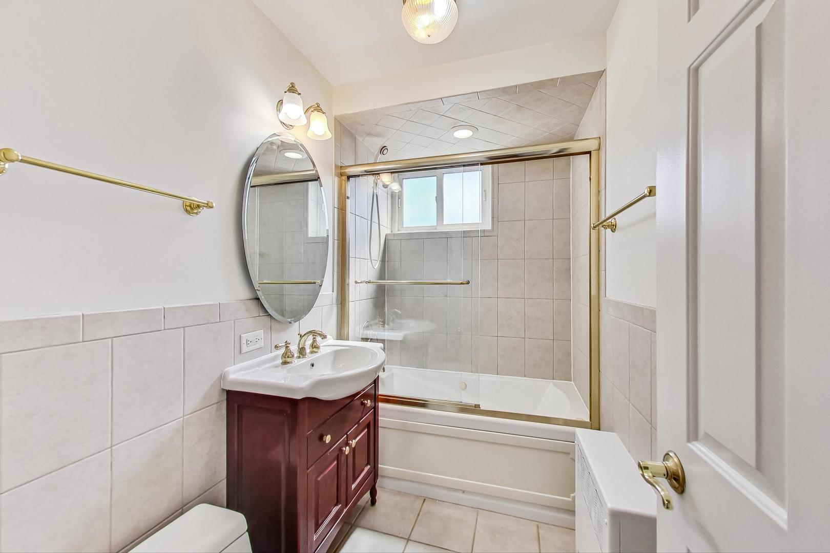 7400 North Sheridan Road, Unit 2 Chicago, IL 60626 - Photo 19 of 23 a bathroom with a bathtub shower sink and mirror