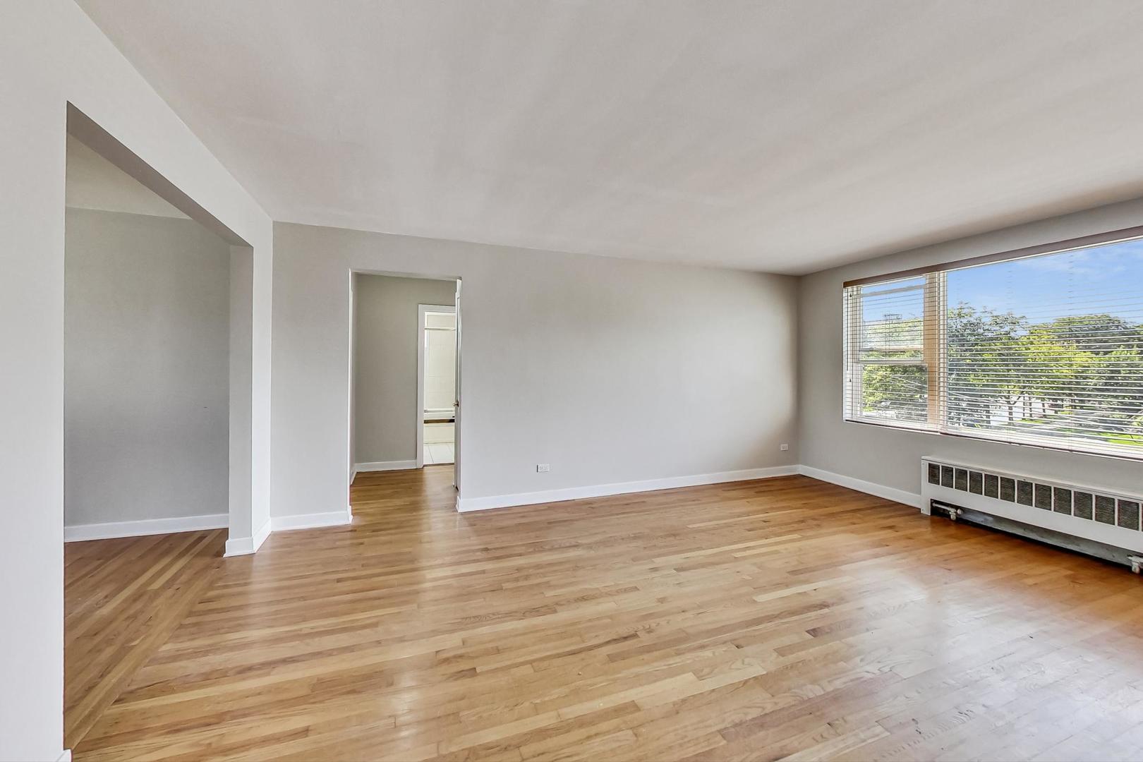 7400 North Sheridan Road, Unit 2 Chicago, IL 60626 - Photo 4 of 23 a view of an empty room with glass door and wooden floor