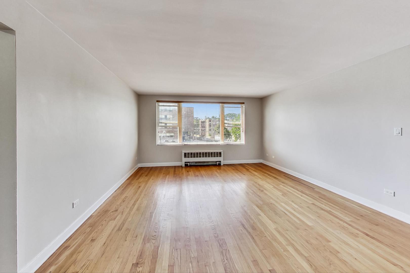 7400 North Sheridan Road, Unit 2 Chicago, IL 60626 - Photo 5 of 23 an empty room with wooden floor and windows