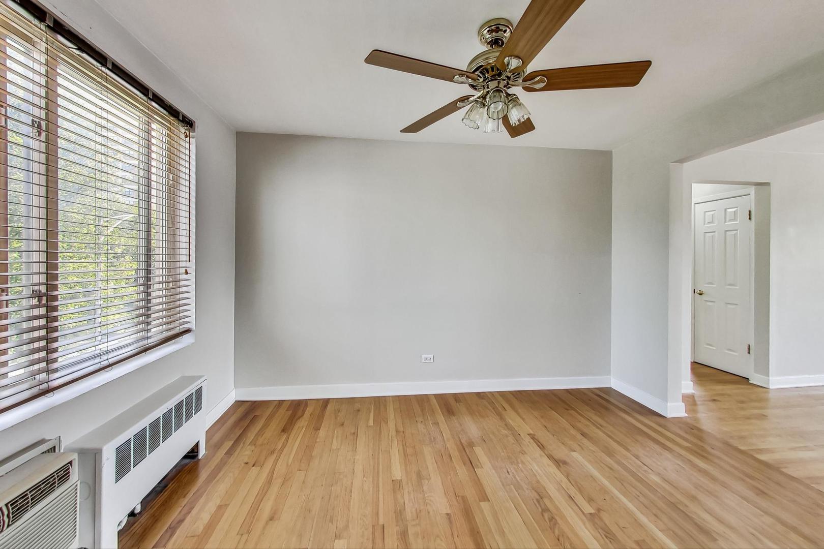 7400 North Sheridan Road, Unit 2 Chicago, IL 60626 - Photo 9 of 23 a view of an empty room with wooden floor and a window