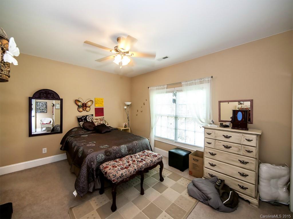 608 Crosswater Lane, Unit 608 Fort Mill, SC 29708 - Photo 13 of 20 a bedroom with a bed and a chandelier