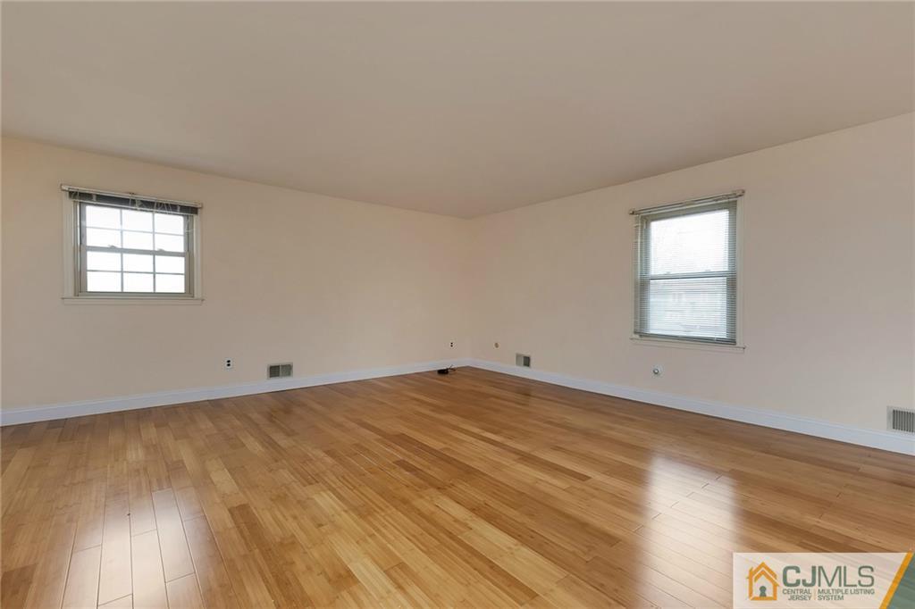 1265 Brookside Road Piscataway, NJ 08854 - Photo 11 of 25 an empty room with wooden floor and windows