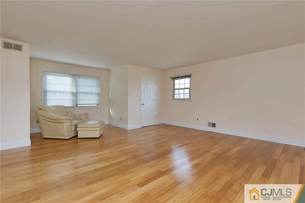 1265 Brookside Road Piscataway, NJ 08854 - Photo 12 of 25 a view of an empty room with window and wooden floor