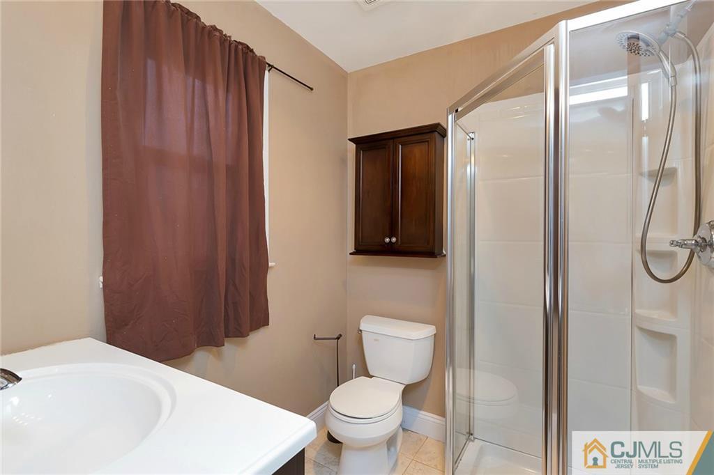 1265 Brookside Road Piscataway, NJ 08854 - Photo 13 of 25 a white toilet sitting next to a bathroom sink and tub