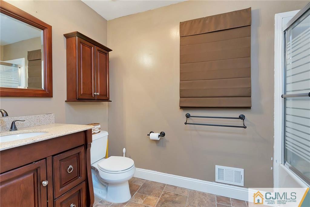 1265 Brookside Road Piscataway, NJ 08854 - Photo 18 of 25 a bathroom with a sink a toilet and mirror