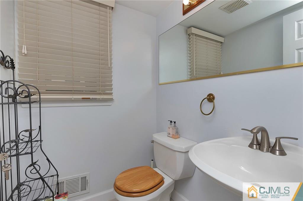 1265 Brookside Road Piscataway, NJ 08854 - Photo 10 of 25 a bathroom with a sink a toilet and mirror