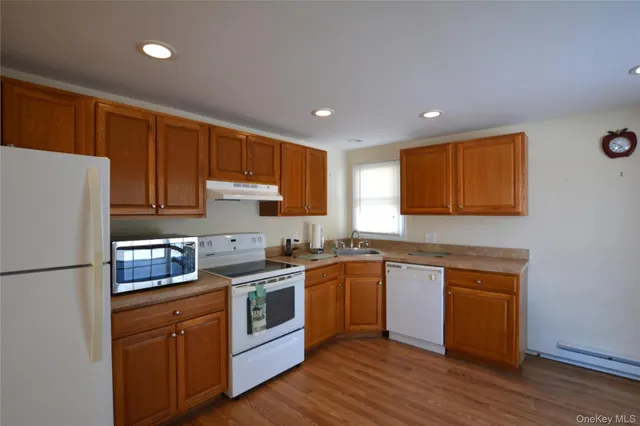 a kitchen with stainless steel appliances granite countertop a refrigerator a sink dishwasher a stove with wooden floors and cabinets