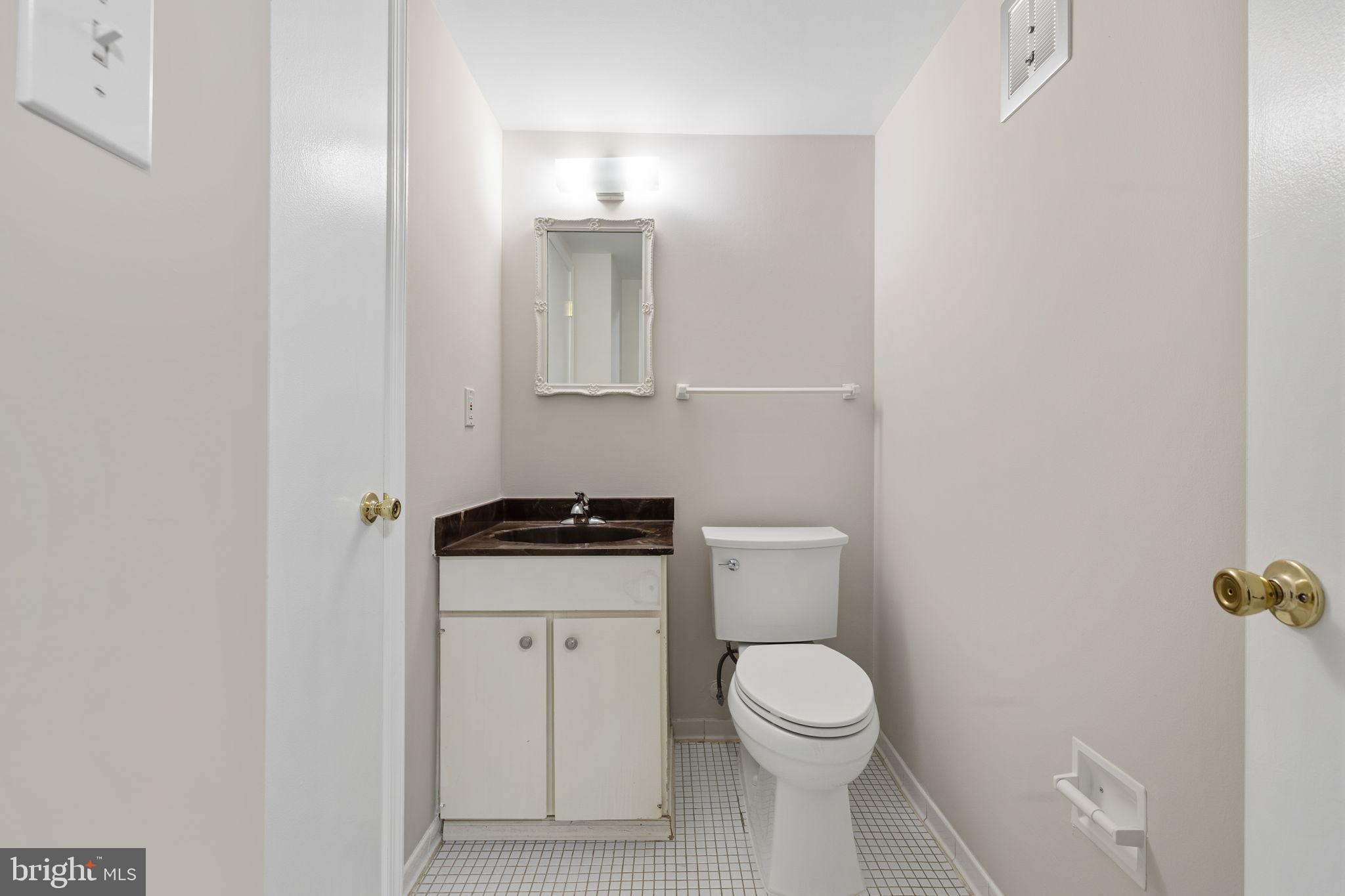 5817 Rexford Drive, Unit 798 Springfield, VA 22152 - Photo 16 of 23 a bathroom with a toilet a sink and mirror