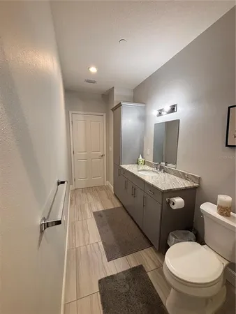 a bathroom with a granite countertop shower and a toilet
