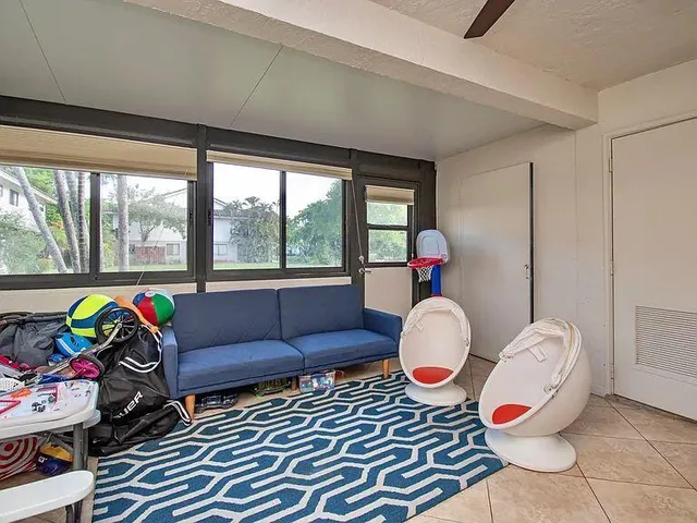 a living room with furniture and a floor to ceiling window