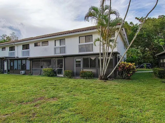 a view of a house with a yard and sitting area