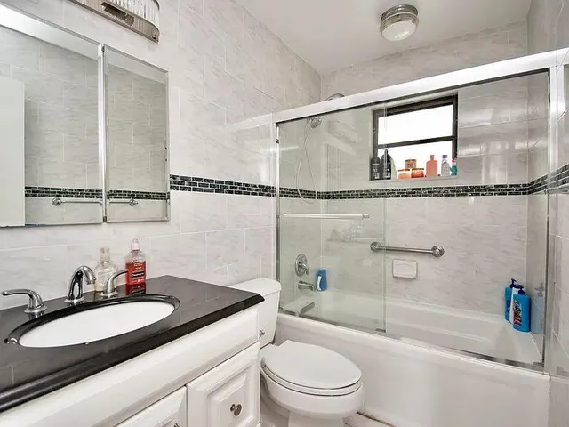 a bathroom with a granite countertop sink mirror vanity and toilet
