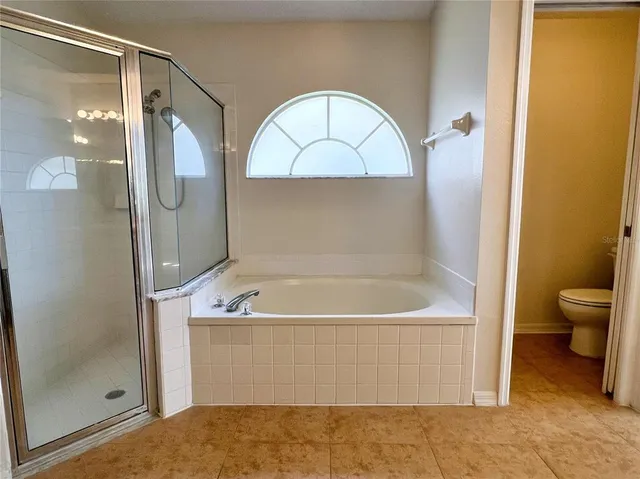 a bathroom with a tub a toilet and a shower