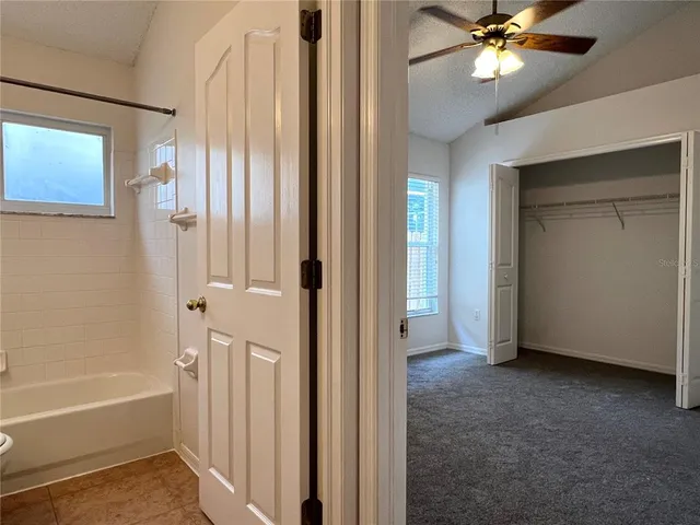 a view of a bathroom with a bathtub and a ceiling fan