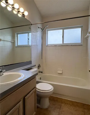 a bathroom with a granite countertop sink a toilet and shower
